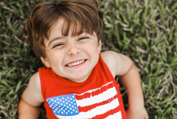 istock Happy baby boy lying on grass 1439118483