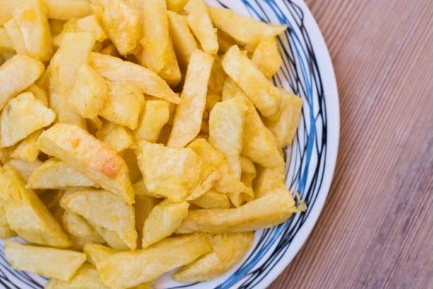 istock French fries on a plate, on a wooden table 1439133371