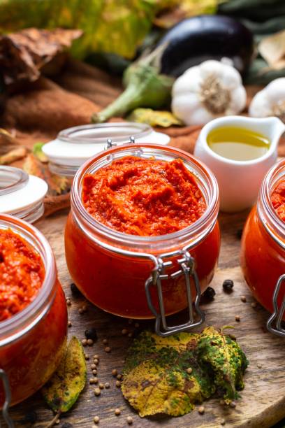 primer plano de ajvar crudo en la mesa con verduras y salsas en el fondo - chutney jar tomato preserved fotografías e imágenes de stock