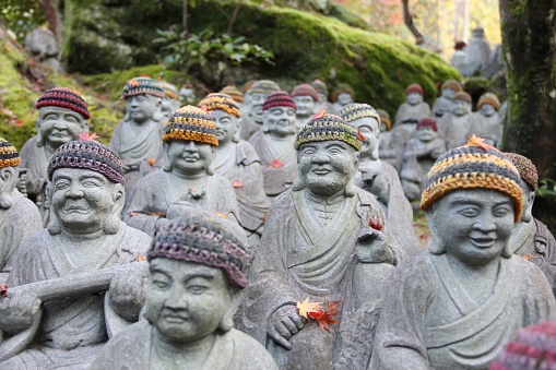 A scenic shot of Buddha statues with colorful wool caps on Miyajima island