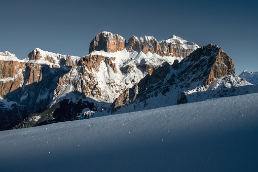 A beautiful scenery of high rocky cliffs covered with snow in the Dolomites