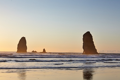 The famous Haystack Rock on the rocky shoreline of the Pacific Ocean