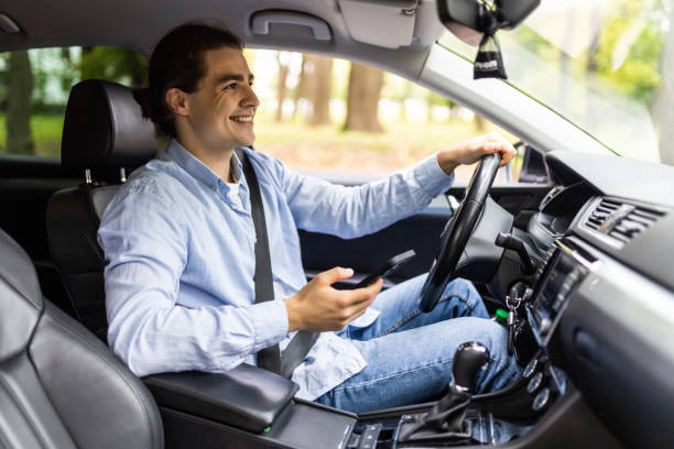 istock Young man driving car and texting on the cellphone 1439138248