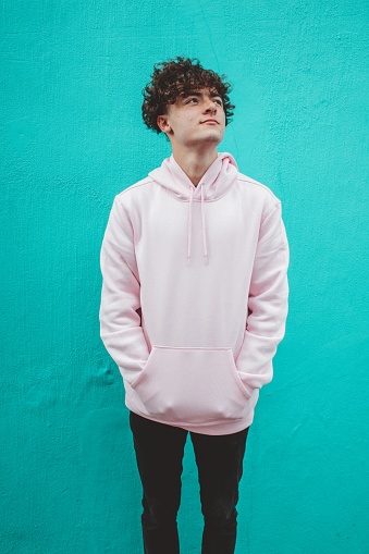 A vertical shot of a south African young man with curly hair wearing a white hoodie