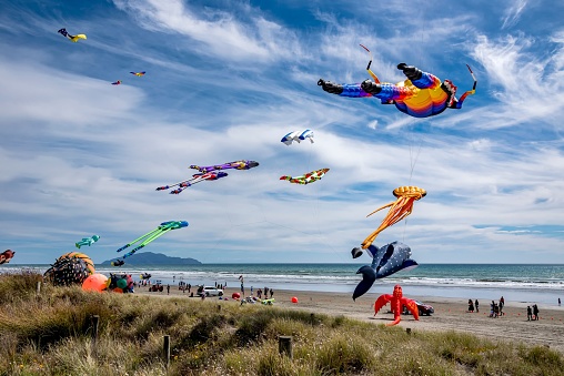Otaki, New Zealand – February 16, 2019: every year at Otaki Beach the kites come out to play in february. The blue sea with Kapiti Island in the distance