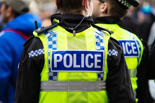 leeds, United Kingdom – May 05, 2019: Police officer wearing a yellow vest with police wrote on the back during tour de yorkshire in leeds city centre