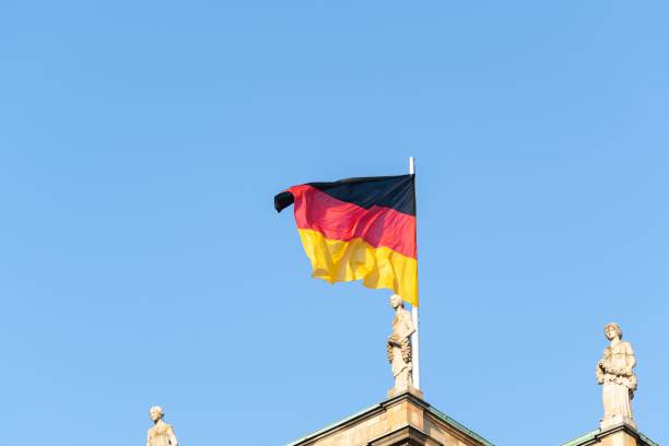 istock Flag of Germany flaunting on the wind under a blue sky 1439140023