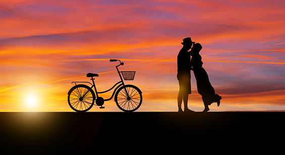 Silhouette at twilight landscape of couple or lover dancing and singing on the mountain with sunset background.