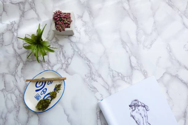 istock THC CBD Marijuana joint and flowers on ash tray with nude illustration on drawing pad 1439141318