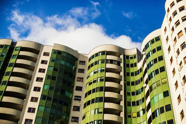 istock Curvy modern green apartment building under the sunlight and a blue sky 1439142315