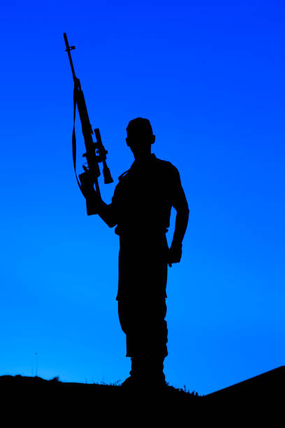 istock Soldier saluting at sunset and twillight with his rifle 1439144508