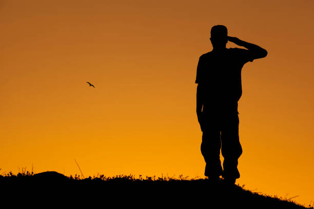 istock Soldier saluting at sunset and twillight with his rifle 1439144543