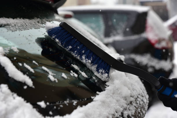 istock Removing snow from the car window with a brush 1439145968