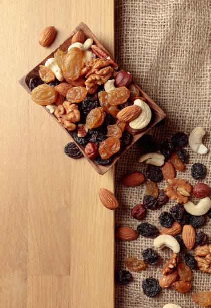 istock Mix of nuts and raisins on a wooden table. 1439150270