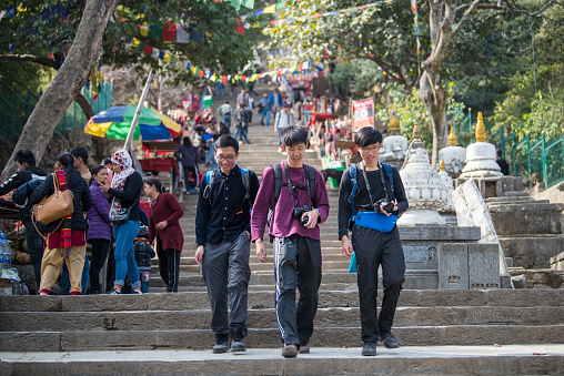 Kathmandu, Nepal- April 20,2022 : Tourists visit the ancient stupas of Swayambhunath temple high above Kathmandu.