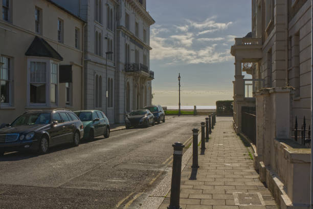 Urban street leading to seafront and beach at Worthing in West Sussex, England. With wind farm in distance.