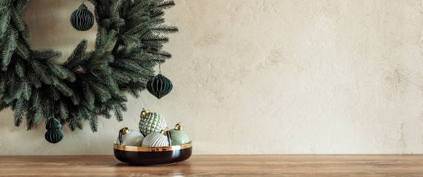 istock Minimal composition with pastel colored baubles in bowl on table with Christmas wreath on textured stone wall 1439164785
