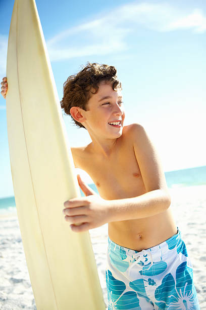 istock Little boy with surfboard on the beach 143916927