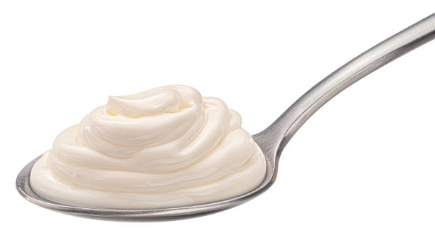 istock Sour cream in spoon isolated on white background 1439169885