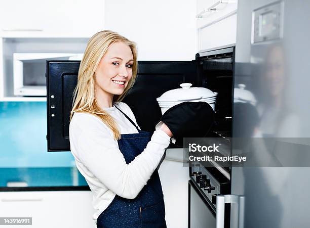 Szczęśliwa Młoda Kobieta Zajmuje Zapiekanka Z Pieca W Nowoczesnej Kuchni - zdjęcia stockowe i więcej obrazów Kobiety