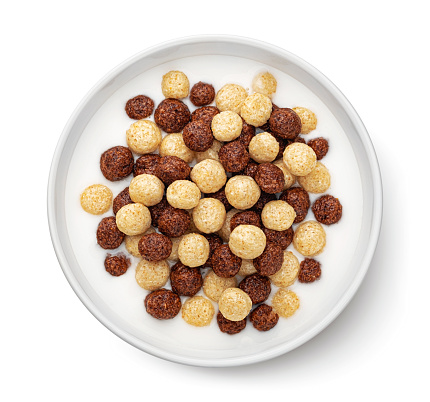 Corn balls with milk cereal breakfast, chocolate and vanilla mix in bowl isolated on white background, top view