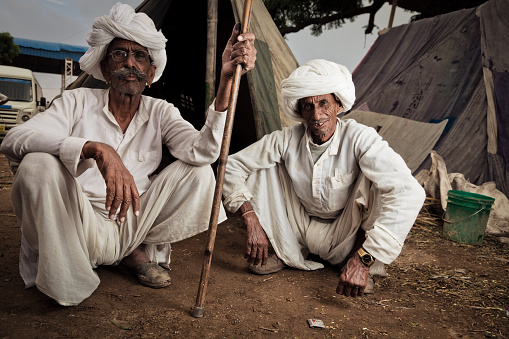 two indian men sitting in front of their tent