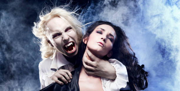 Male Vampire is biting a beautiful woman.  vampire woman stock pictures, royalty-free photos & images