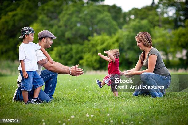 Photo libre de droit de Enfants Apprendre À Marcher Avec Famille Heureuse À Lextérieur banque d'images et plus d'images libres de droit de Premiers pas