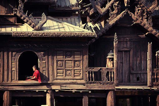 A young monk studying by a window in the Myoe Daung Monastery in Bagan.