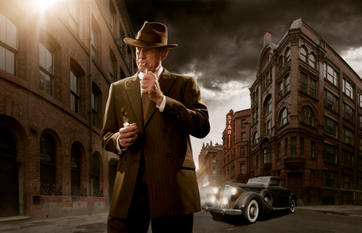 1940's stylised film noir gangster / detective in city with car in background