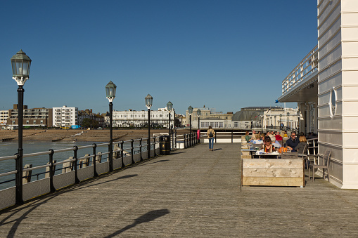 Terrace cafe and restaurant on end of pier at Worthing in West Sussex, England. With people seated at tables.
