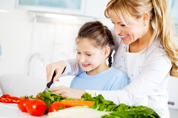 istock Mother and daughter cutting vegetables in the kitchen. 143917302