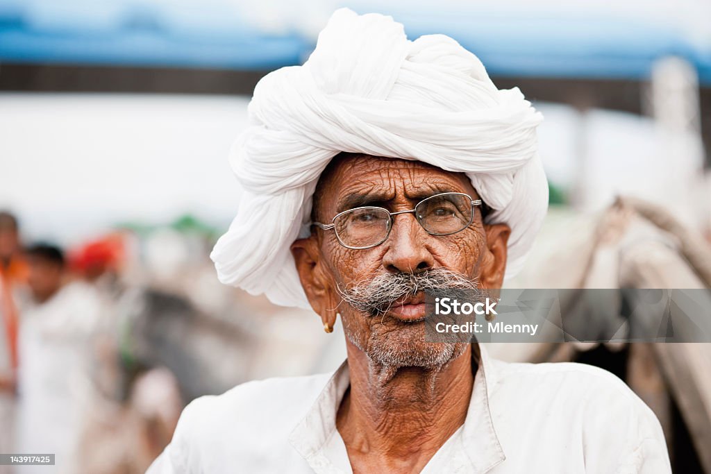 Merchant at Pushkar Camel Fair India Real People Portrait Indian Merchant with white turban at the Pushkar Camel Fair, Pushkar, Rajasthan, India. Real People Portrait.  Culture of India Stock Photo