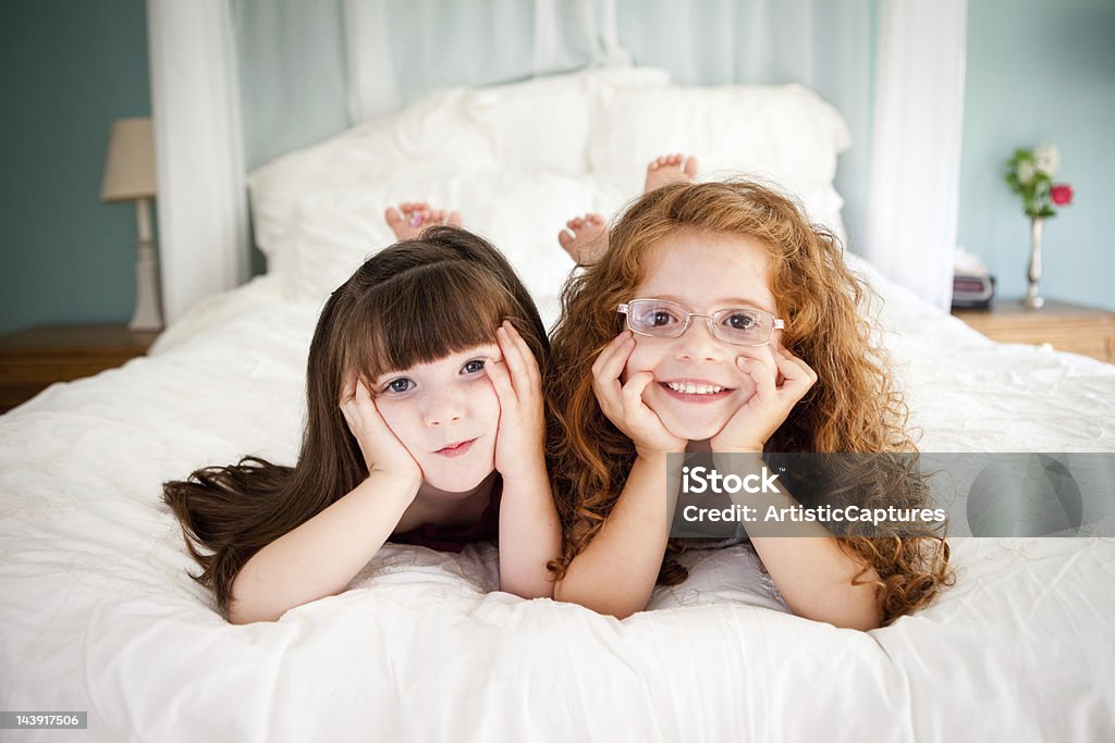 Niedlich, glücklich Schwestern liegen auf dem Bett zusammen im Schlafzimmer - Lizenzfrei 2-3 Jahre Stock-Foto