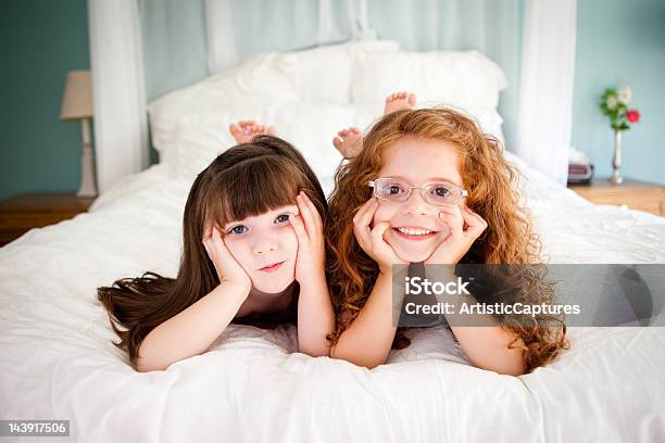 Niedlich Glücklich Schwestern Liegen Auf Dem Bett Zusammen Im Schlafzimmer Stockfoto und mehr Bilder von 2-3 Jahre