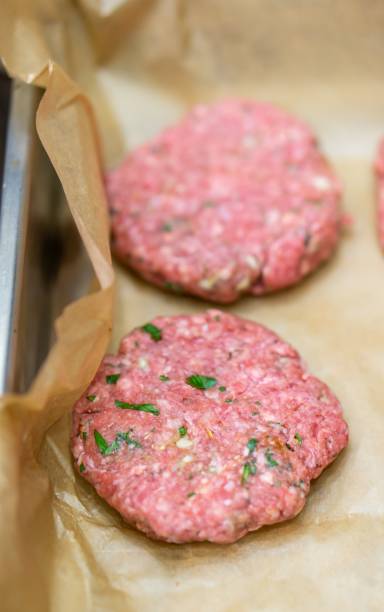 istock High angle shot of two burger cutlets on a baking paper 1439176291