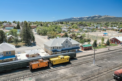 Ely, Nevada, United States – May 25, 2020: Train cars, including a caboose, sit on the tracks at the Northern Nevada Railway Museum.