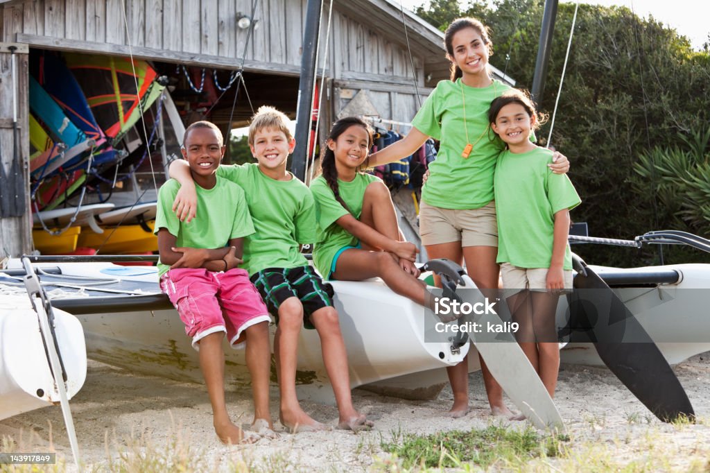 Adolescente e bambini davanti Attrezzatura per sport acquatico shack - Foto stock royalty-free di Campo estivo