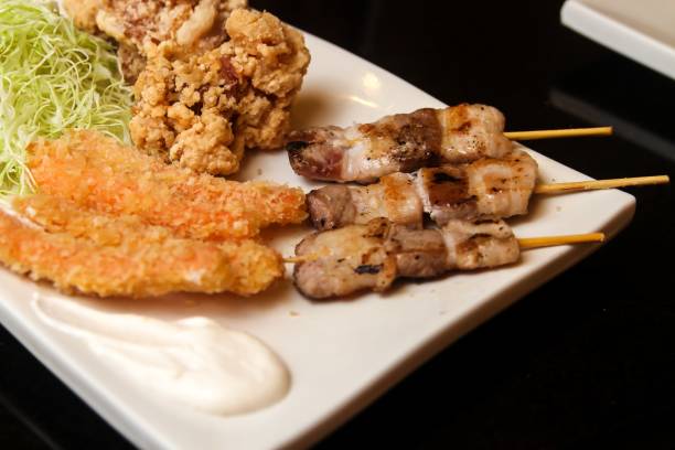 istock Fried and roasted meat pieces and cut cabbage served on a white plate 1439178545