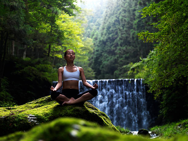 mulher fazendo yoga na natureza - waterfall health spa man made landscape - fotografias e filmes do acervo