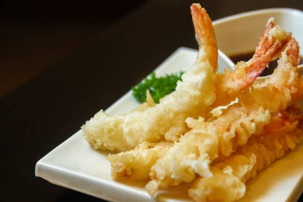 istock Fried shrimps with greens garnish and sauce served on a white flat tray 1439178559