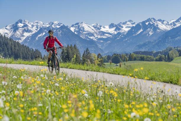 mujer mayor en bicicleta de montaña eléctrica - bavaria allgau germany landscape fotografías e imágenes de stock