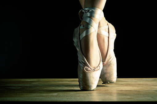 Close up of a classic dancer en pointe on stage.