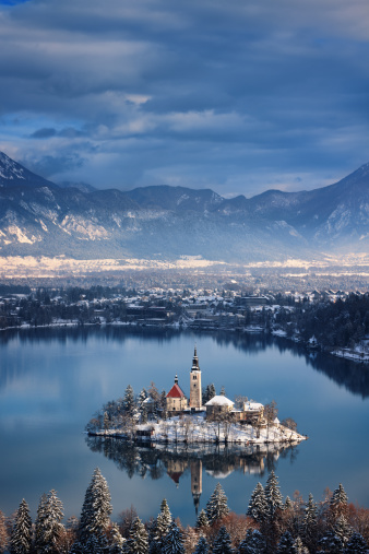 AERIAL: Picturesque alpine Lake Bled with island and church in autumn shades. Gorgeous Bled island with church in embrace of vivid autumn trees. Beautiful fall season creating picturesque views.