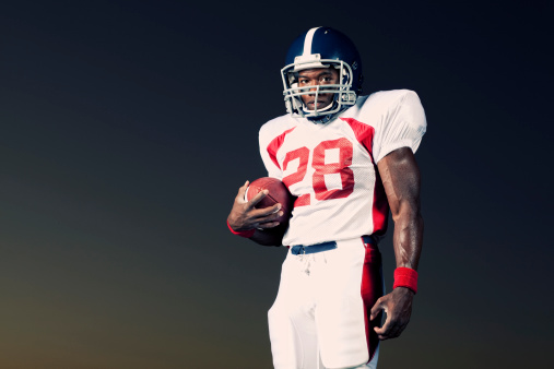 Portrait of an African American tail back. American tackle football player ready to blow through the line past you.