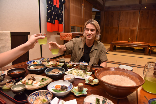 Japanese tourists cheering with a tea in an experiencial hotel in Tabinoya, Shizuoka, Japan