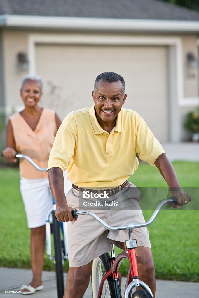 Senior African American couple riding bicycles, focus on man Senior African American couple riding bicycles, focus on man. 50-59 Years Stock Photo