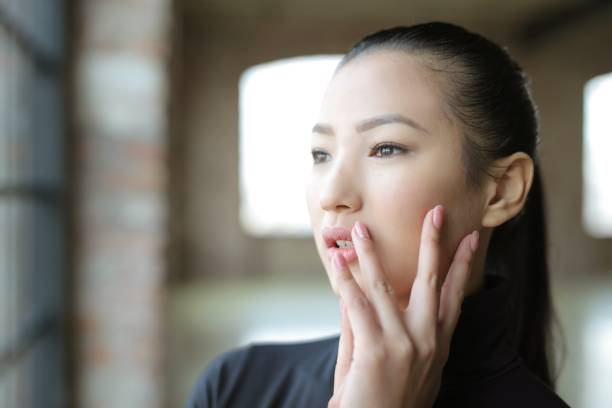 istock Young Asian female looking out the window during daytime 1439183200