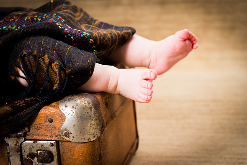 A baby left on a suitcase covered with a blanket - divorce, single parent concept