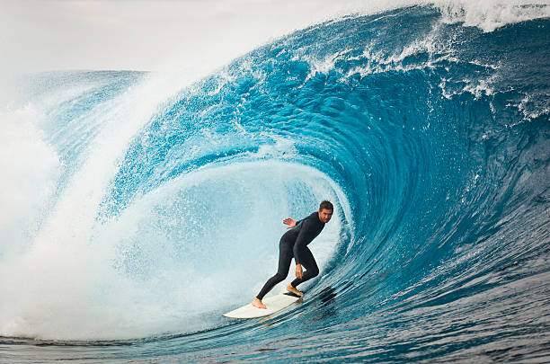 Standing Tall A male surfer cruising along a huge wave. extreme sports stock pictures, royalty-free photos & images